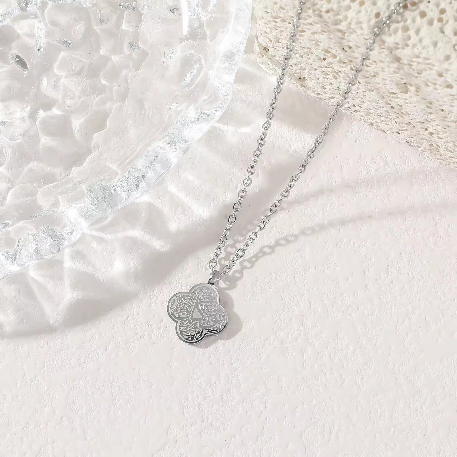 Silver four-leaf clover Shukr Arabic calligraphy pendant necklace on white background