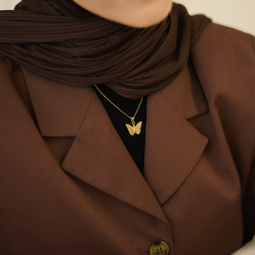 Gold butterfly necklace lifestyle shot with dark moody background - CIGAONI
