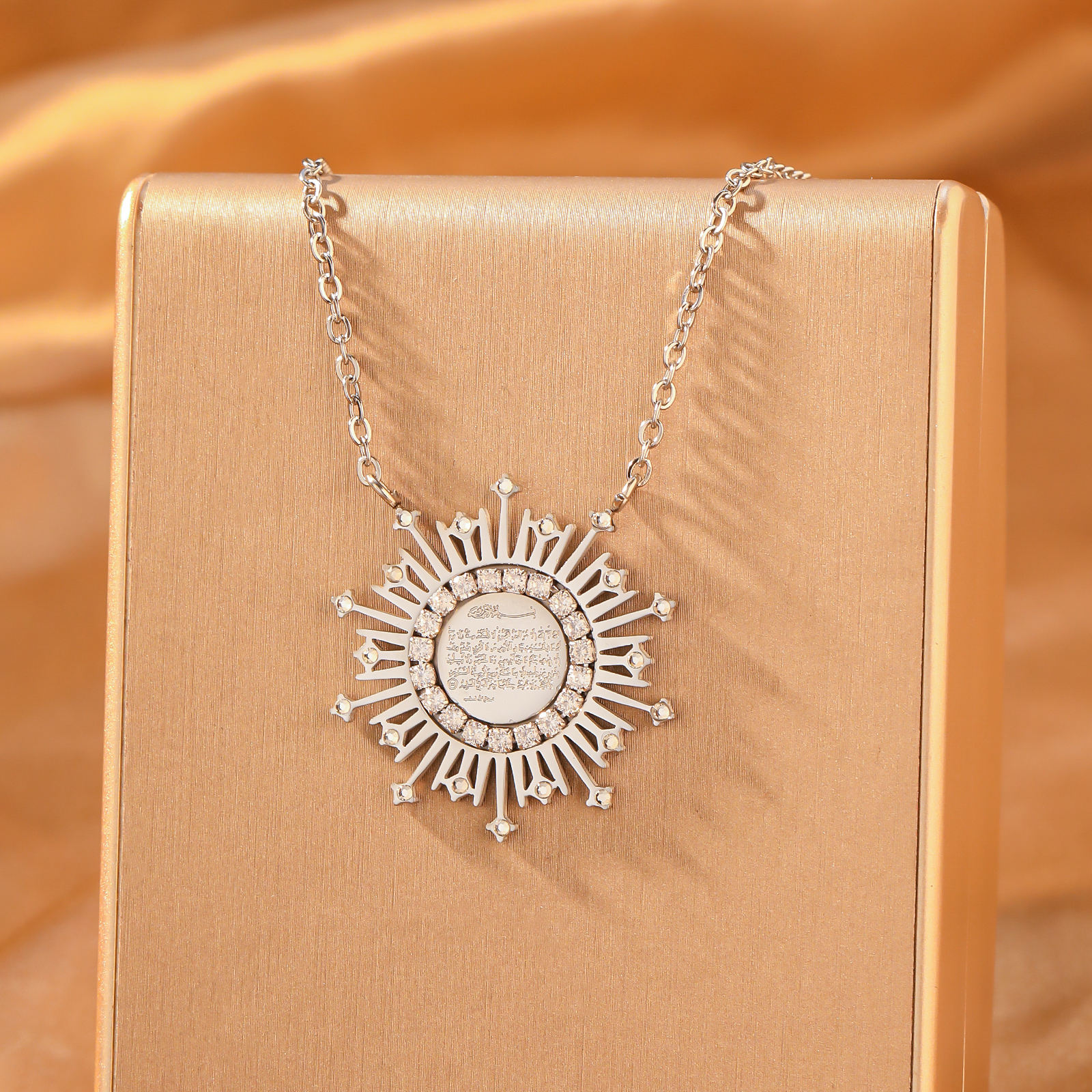 CIGAONI silver Ayatul Kursi sunburst necklace with cubic zirconia crystals on jewelry display stand