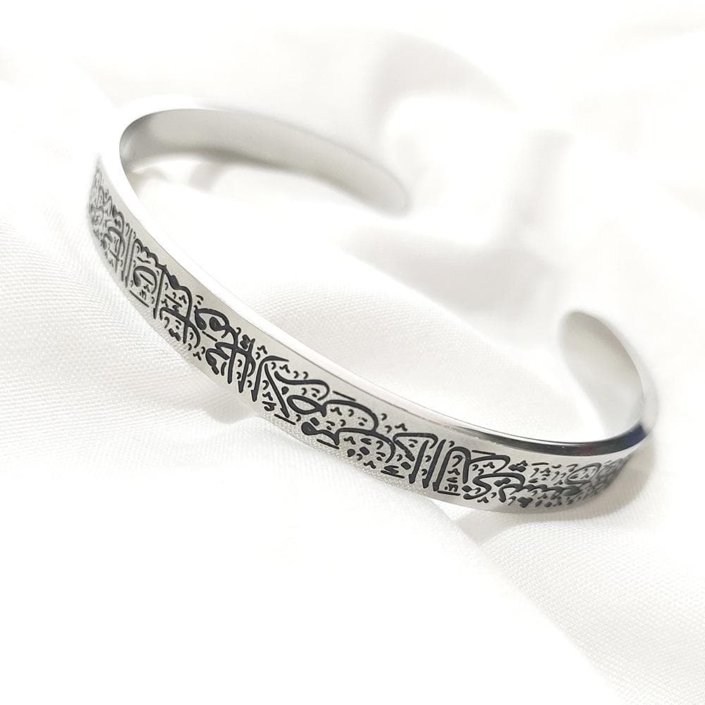 CIGAONI silver Ayatul Kursi open cuff bangle with deep-etched Arabic calligraphy on white fabric

