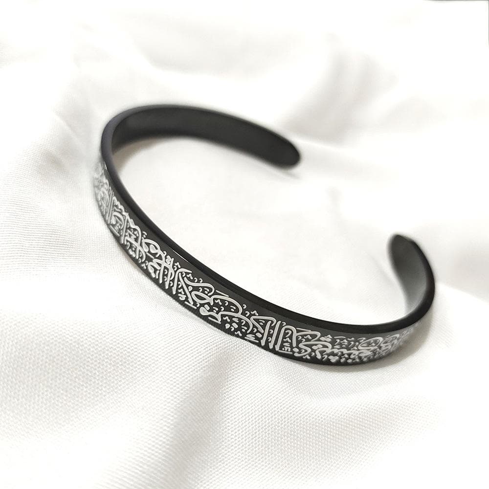 CIGAONI matte black Ayatul Kursi open cuff bangle with silver Arabic calligraphy engraving on white fabric

