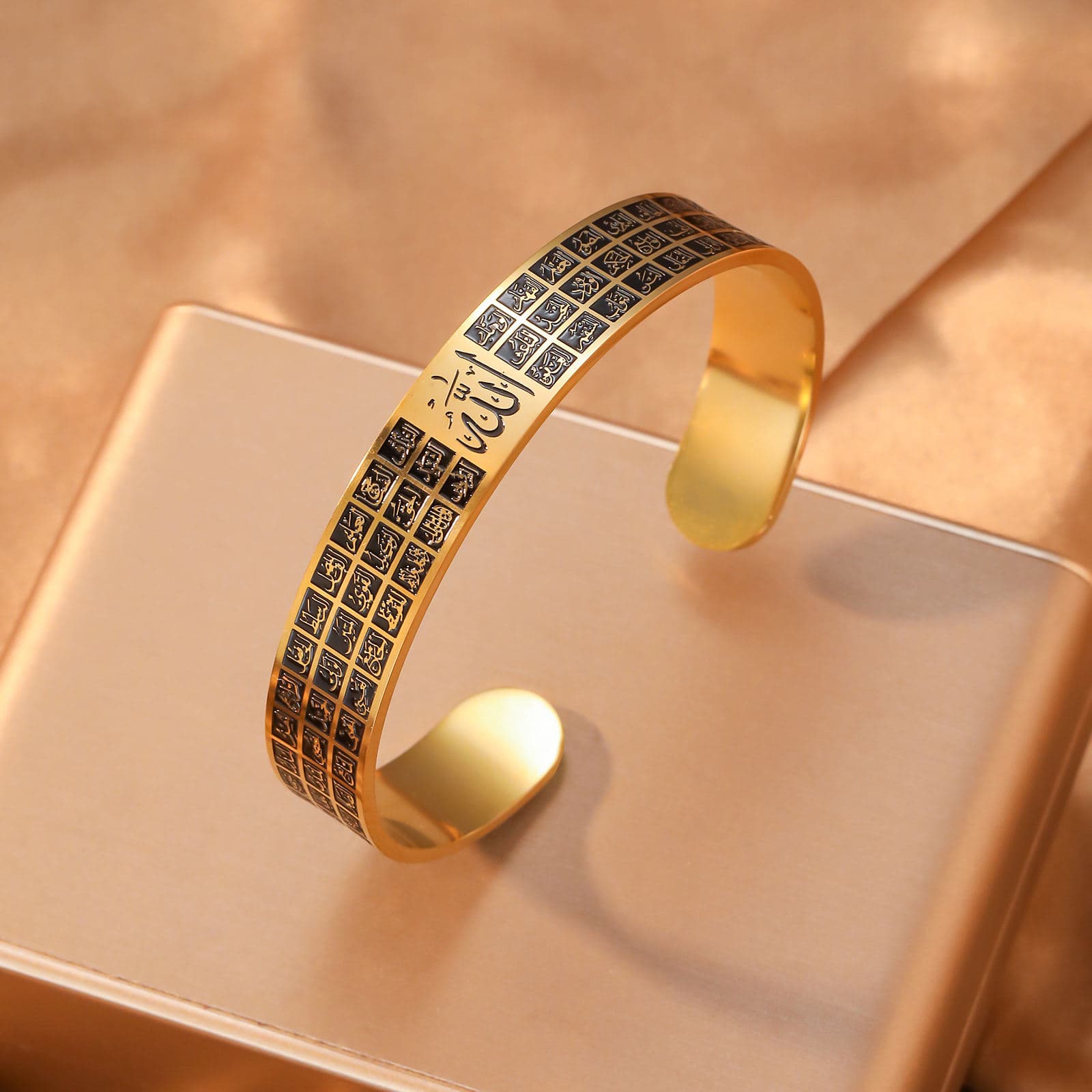 CIGAONI gold-black Asma-ul-Husna open cuff bangle with Allah calligraphy and 99 Names grid engraving on display stand