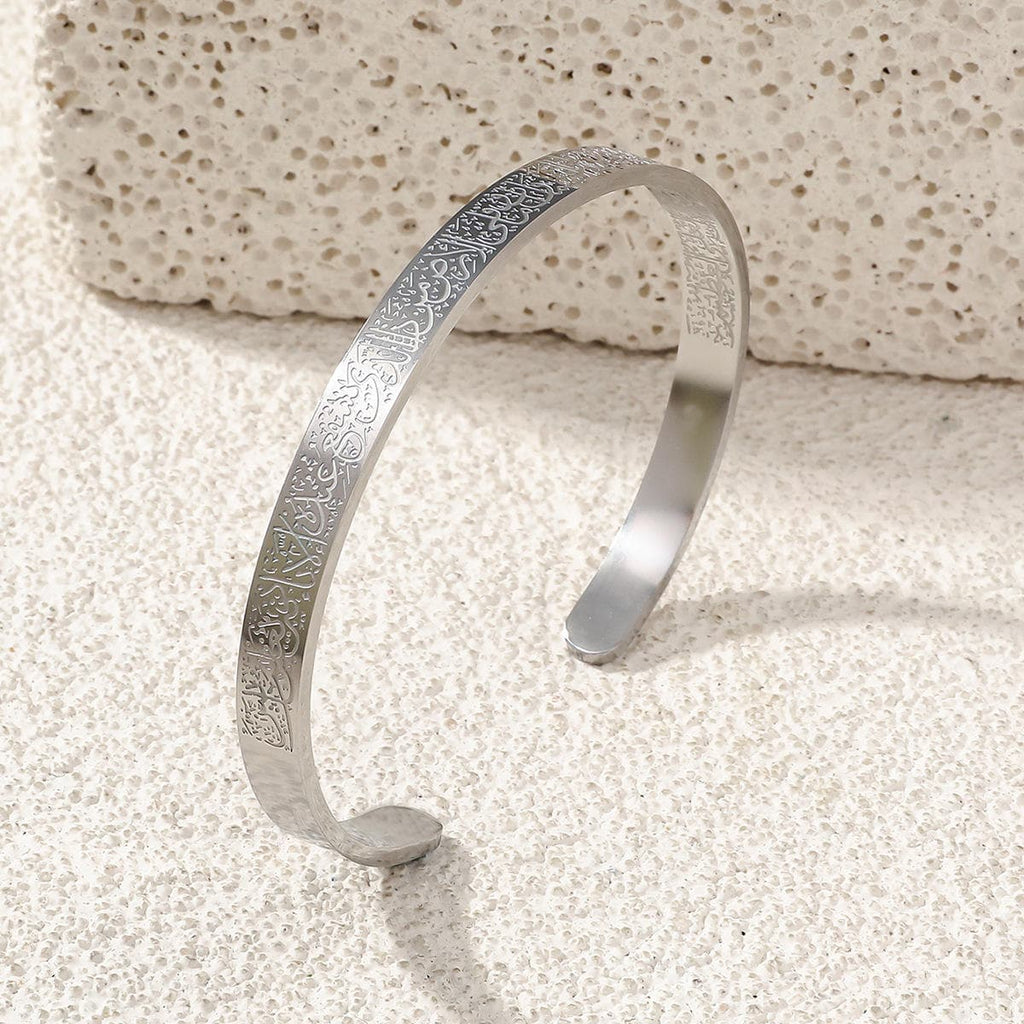 CIGAONI Pure Sanctuary Ayatul Kursi radiant silver open cuff bangle with full Arabic calligraphy engraving on stone surface

