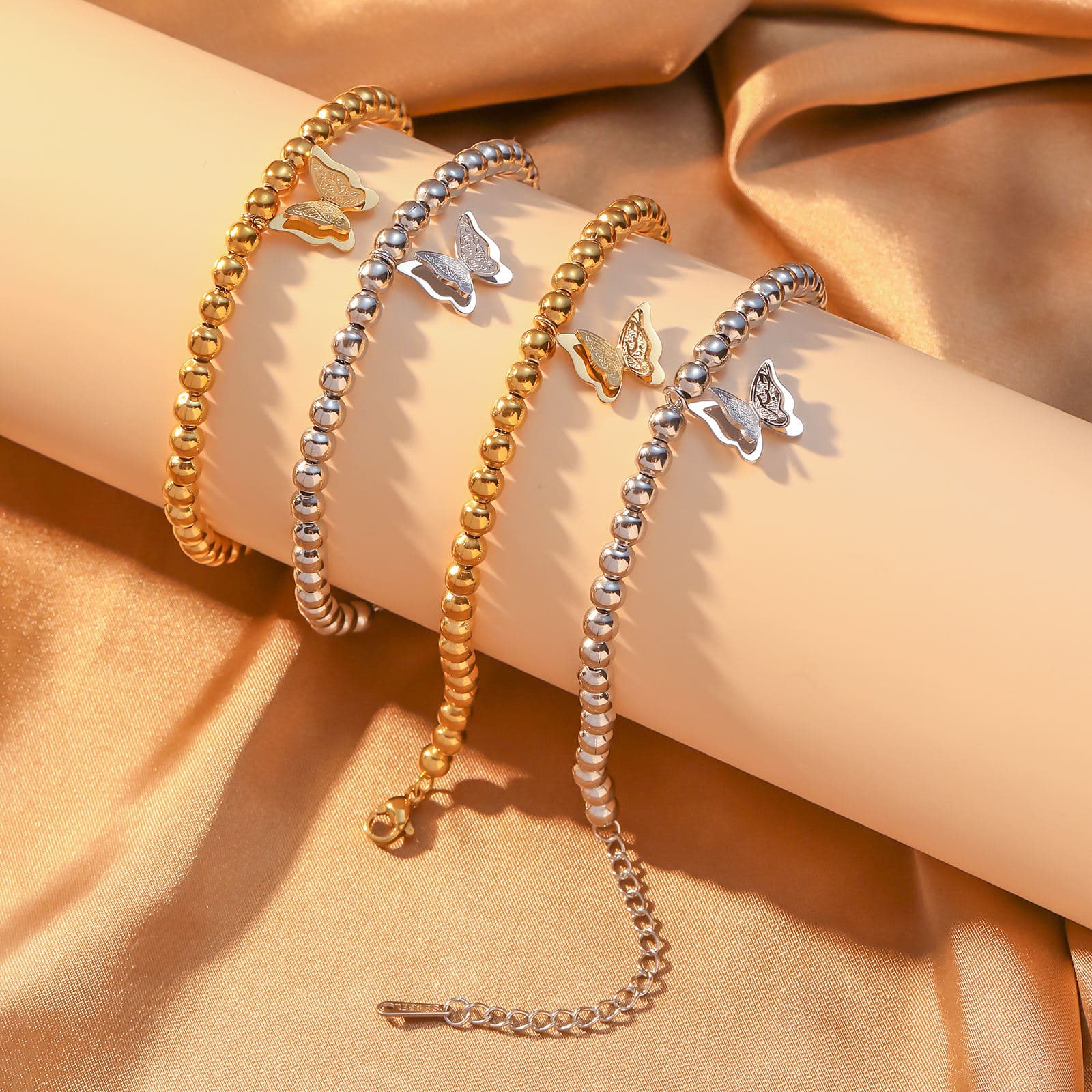 CIGAONI Wings of Amal gold butterfly beaded bracelet worn on wrist, 18K gold finish, double-layer filigree butterfly charm, 316L stainless steel