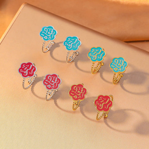 CIGAONI Bloom of Salam adjustable rings flat lay – teal and ruby red enamel Arabic calligraphy flower rings in 18K gold and silver, multiple variants displayed together
