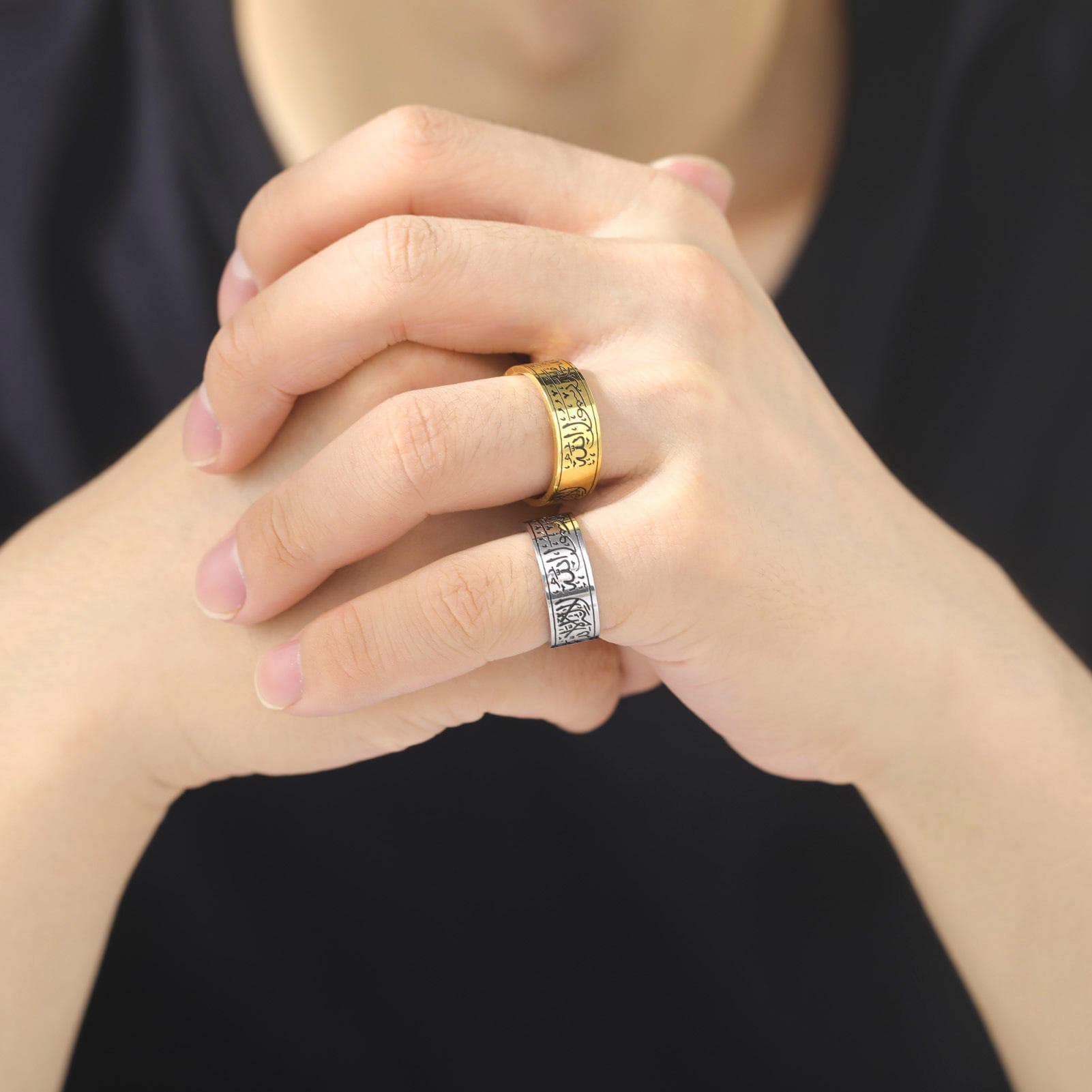 Model wearing CIGAONI Sovereign Verse Ring in both gold and silver finishes on clasped hands, showcasing the bold 8mm Arabic calligraphy band in a lifestyle setting

