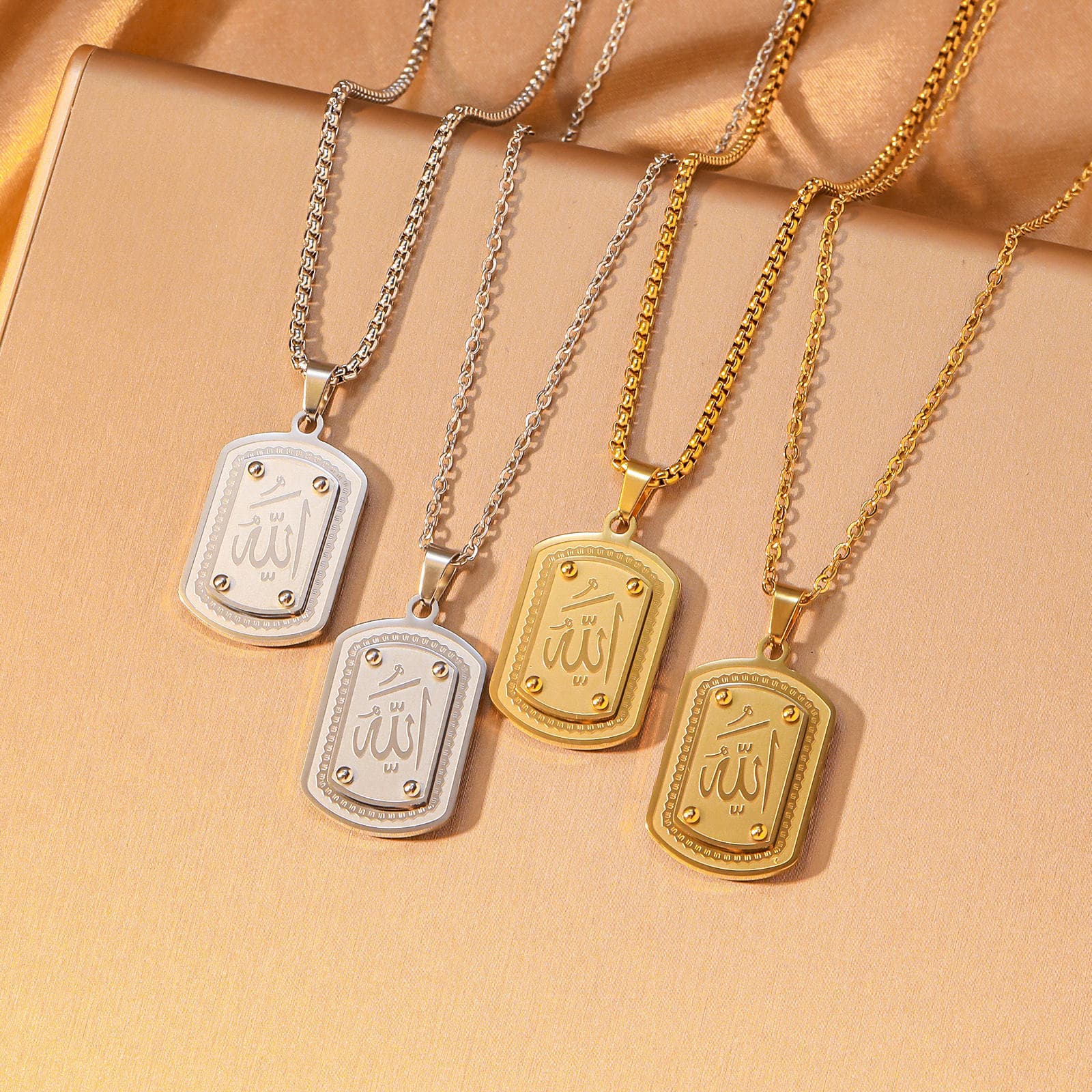 "CIGAONI Allah Arabic Calligraphy Rectangular Plaque Necklace in four finishes – gold, silver, rose gold, and black – displayed on warm beige background"