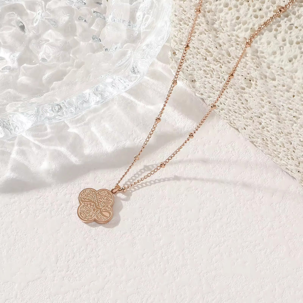 Silver four-leaf clover Tawakkul Arabic calligraphy pendant necklace on white background