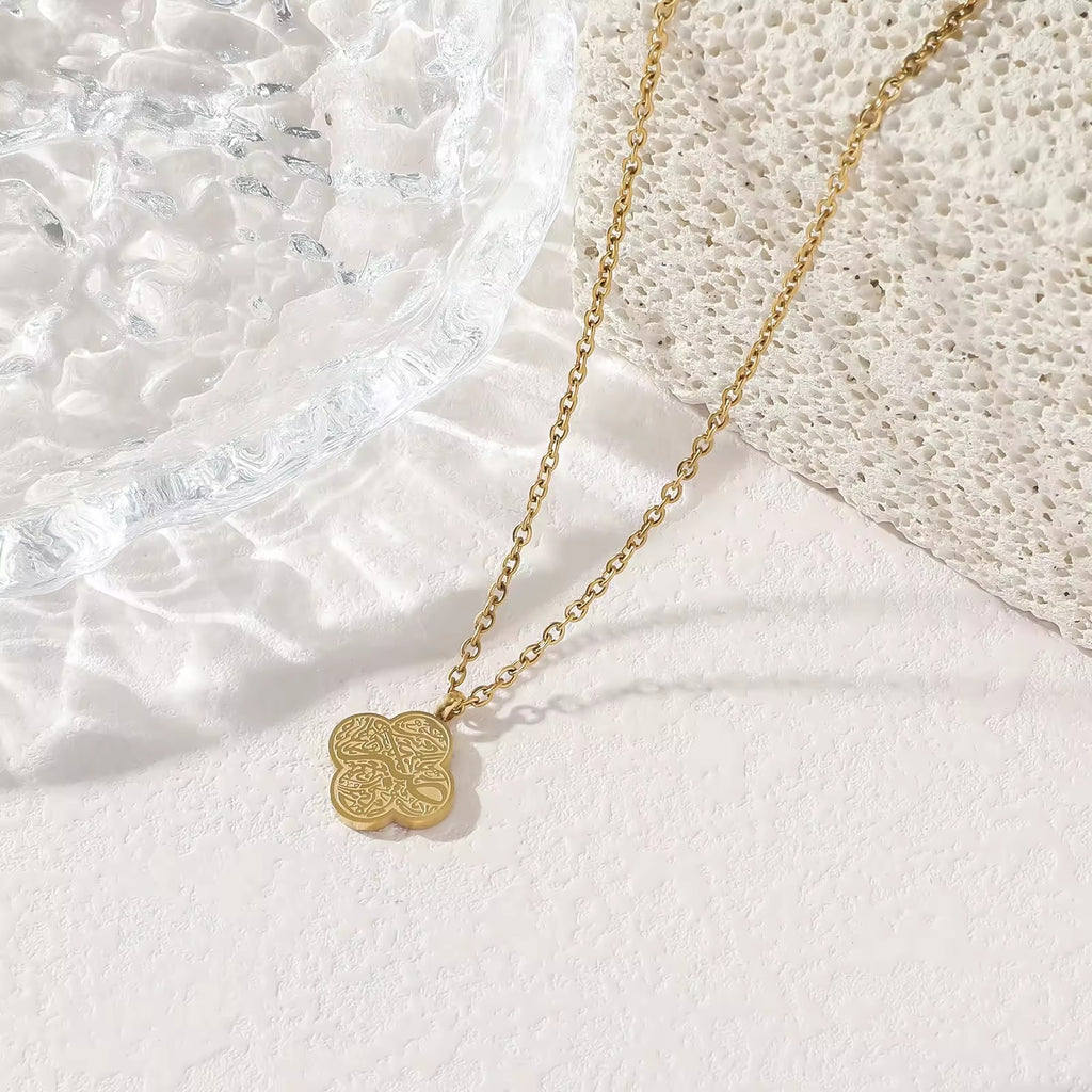 Rose gold four-leaf clover Tawakkul Arabic calligraphy pendant necklace on white background