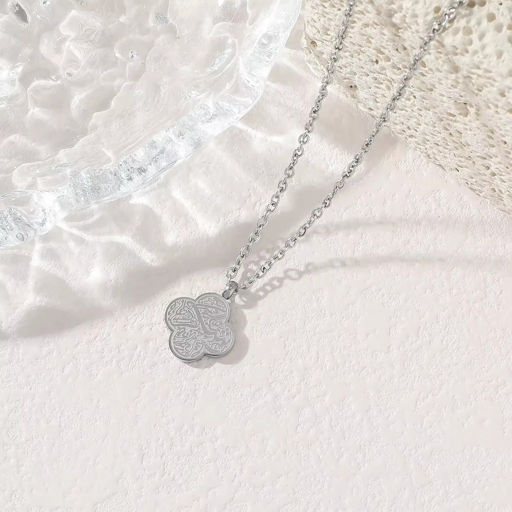 Silver four-leaf clover Sabr Arabic calligraphy pendant necklace on white background