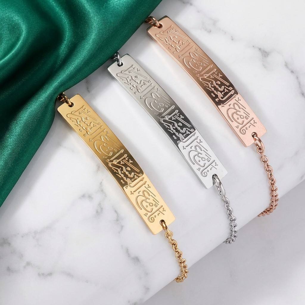 CIGAONI Ayatul Kursi Bar Bracelet in gold, silver and rose gold, engraved with Arabic calligraphy, displayed on marble with green satin