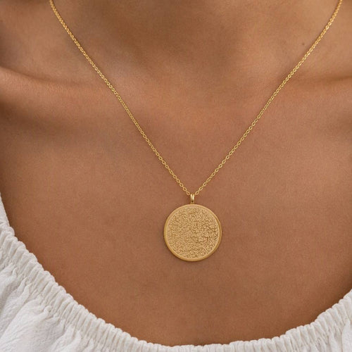 Woman wearing CIGAONI 18K Gold Ayatul Kursi Circle Medallion Necklace on collarbone - full verse Arabic calligraphy engraved pendant on cable chain