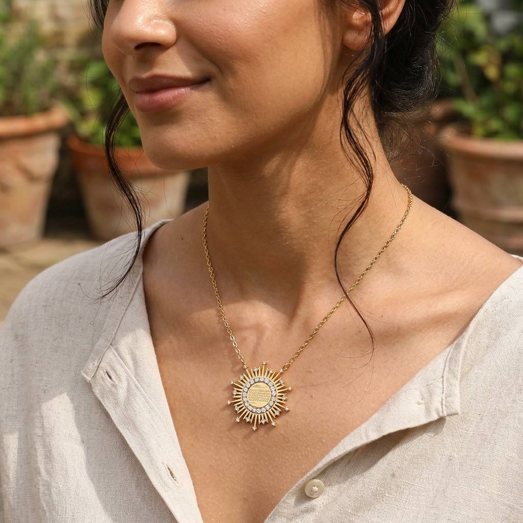 Woman wearing CIGAONI 18K gold Ayatul Kursi sunburst necklace with zircon crystals outdoors