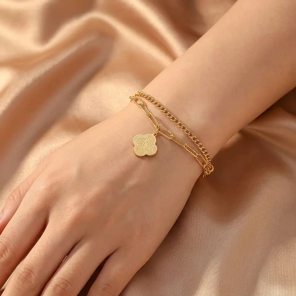 Model wearing CIGAONI gold layered faith bracelet - Elegant Arabic calligraphy jewelry on wrist with champagne silk background