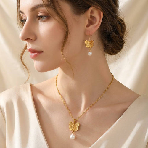 Elegant model wearing CIGAONI gold butterfly pearl necklace and drop earrings - Sacred Islamic faith inspired jewelry for women