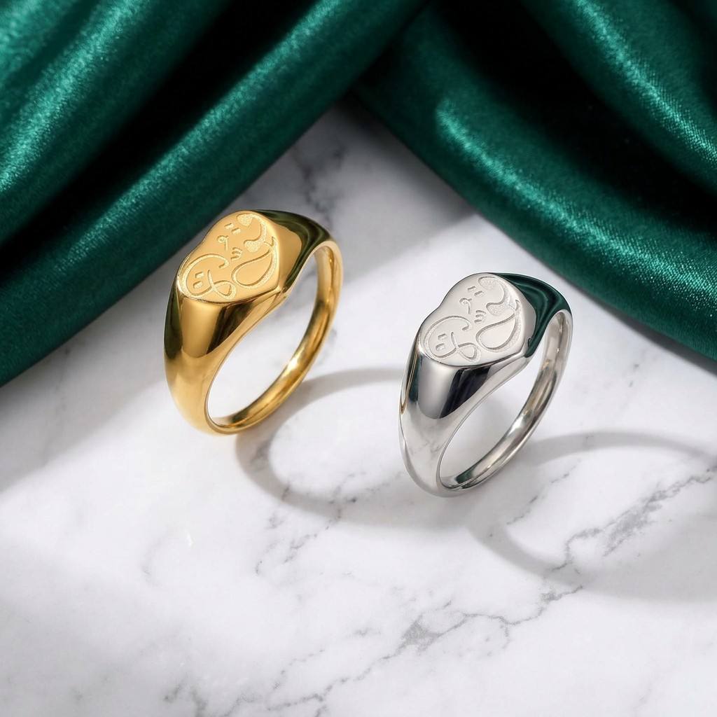 CIGAONI Sacred Hubb gold and silver heart-shaped Arabic love calligraphy signet rings on white marble with green silk backdrop

