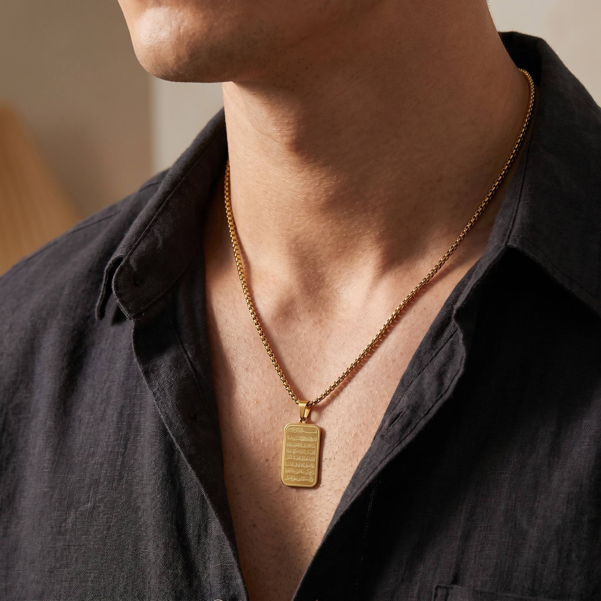 Man wearing CIGAONI 18K gold Ayatul Kursi plaque necklace with box chain on dark shirt