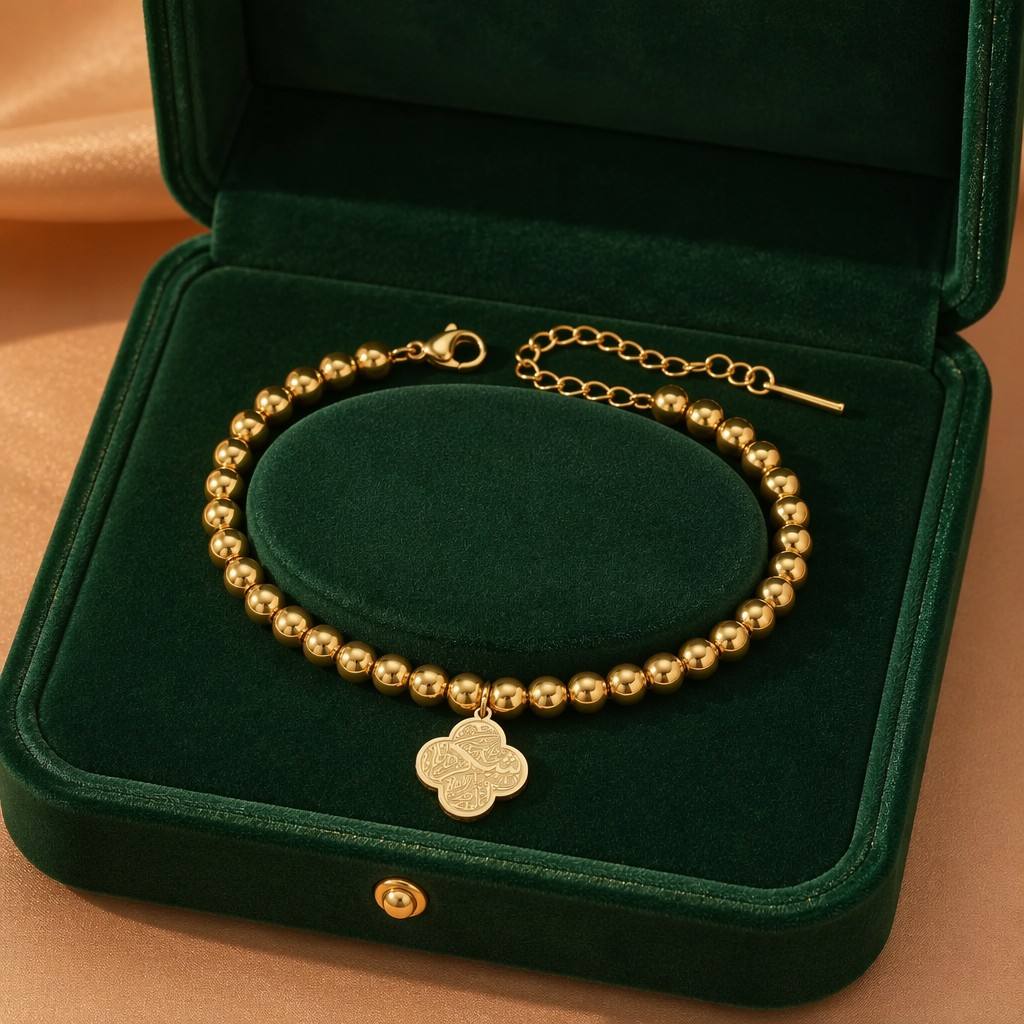 CIGAONI Clover of Virtue gold beaded bracelet on wrist, side angle view showing Arabic calligraphy quatrefoil charm and lobster clasp extender chain