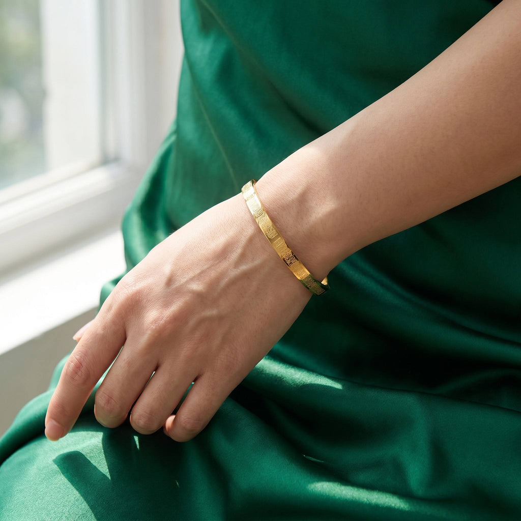 CIGAONI dainty Ayatul Kursi gold cuff bangle worn by female model against emerald silk