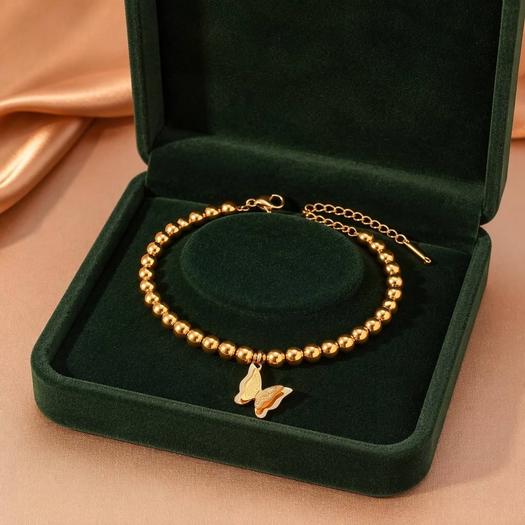CIGAONI Wings of Amal gold butterfly beaded bracelet displayed in luxury emerald green jewelry box, lobster clasp and extender chain visible


