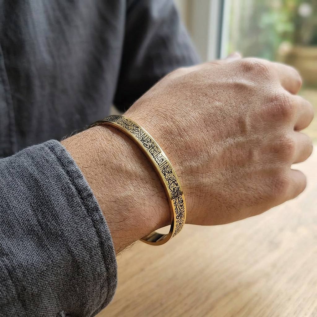 Man wearing CIGAONI 18K gold Ayatul Kursi open cuff bangle with black engraved Arabic calligraphy on wrist

