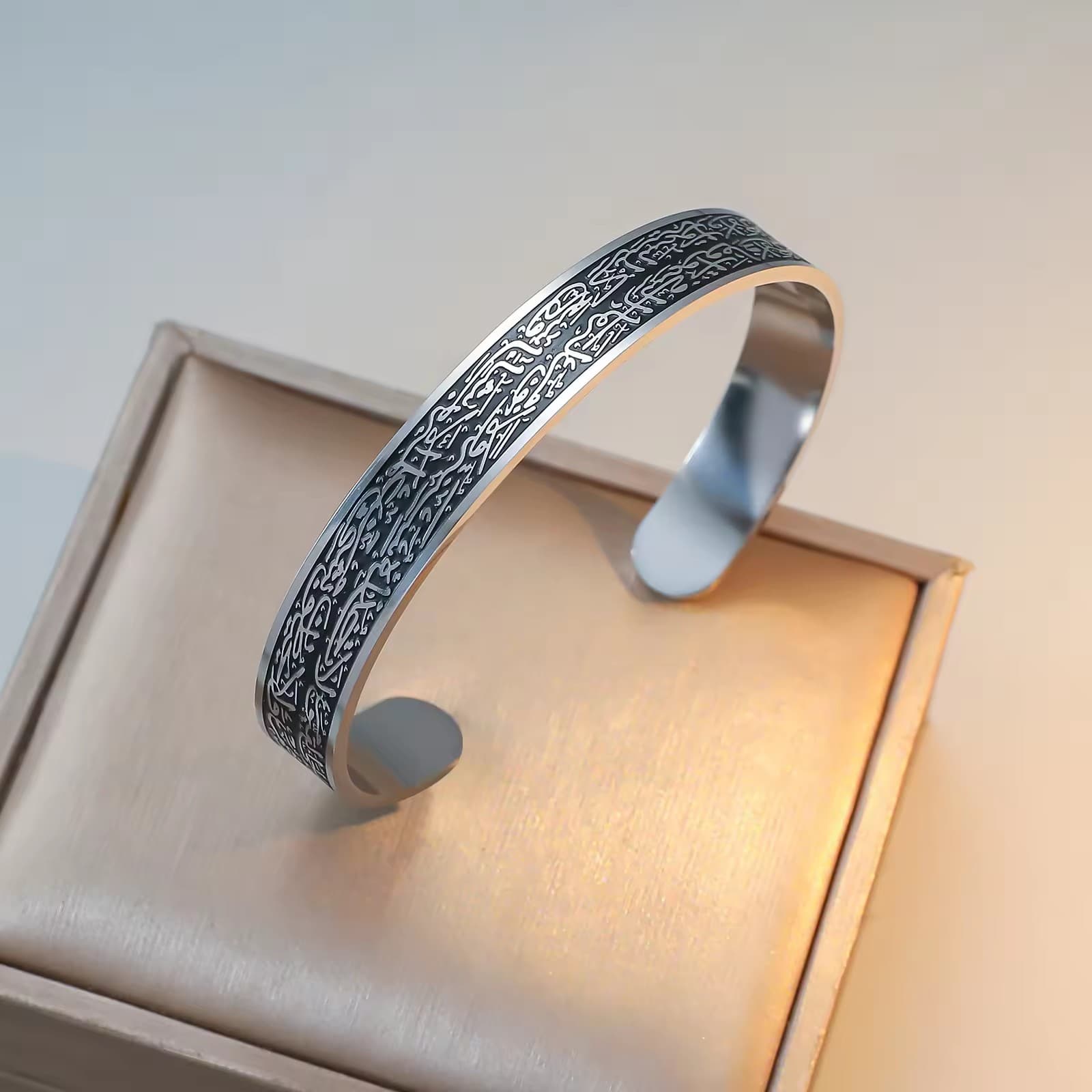 CIGAONI Sovereign Shield silver-black Ayatul Kursi open cuff bangle with laser-etched Arabic calligraphy, resting on beige gift box