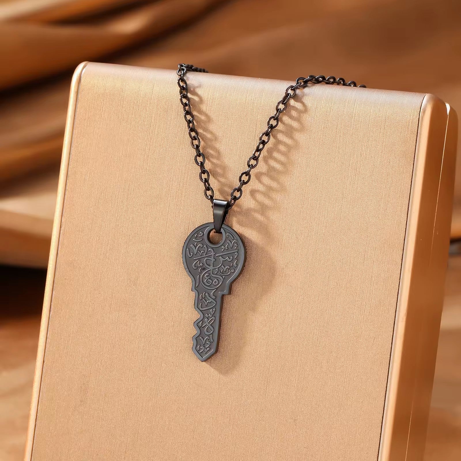 Gold key pendant necklace on beige gift box