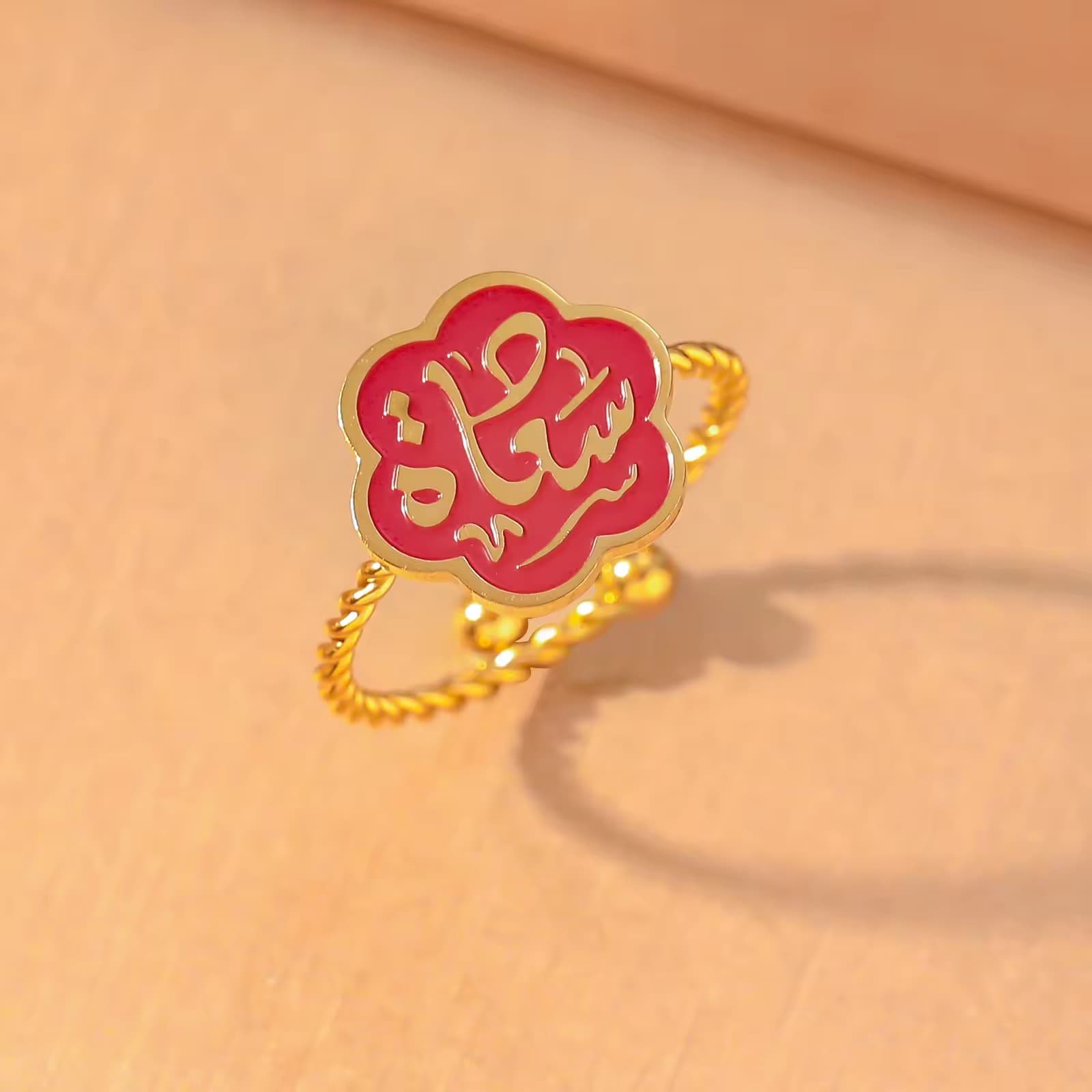 CIGAONI Bloom of Salam ruby red enamel Arabic calligraphy flower ring in 18K gold – close-up product shot on neutral background

