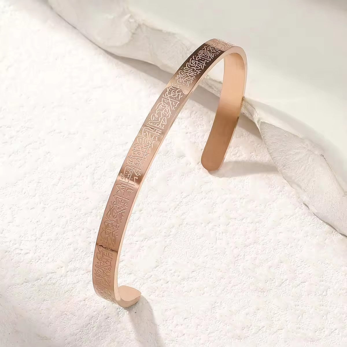 Rose gold open cuff bracelet on white background