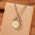 CIGAONI teardrop pendant necklace in gold finish with white mother-of-pearl center stone, front view on neutral background