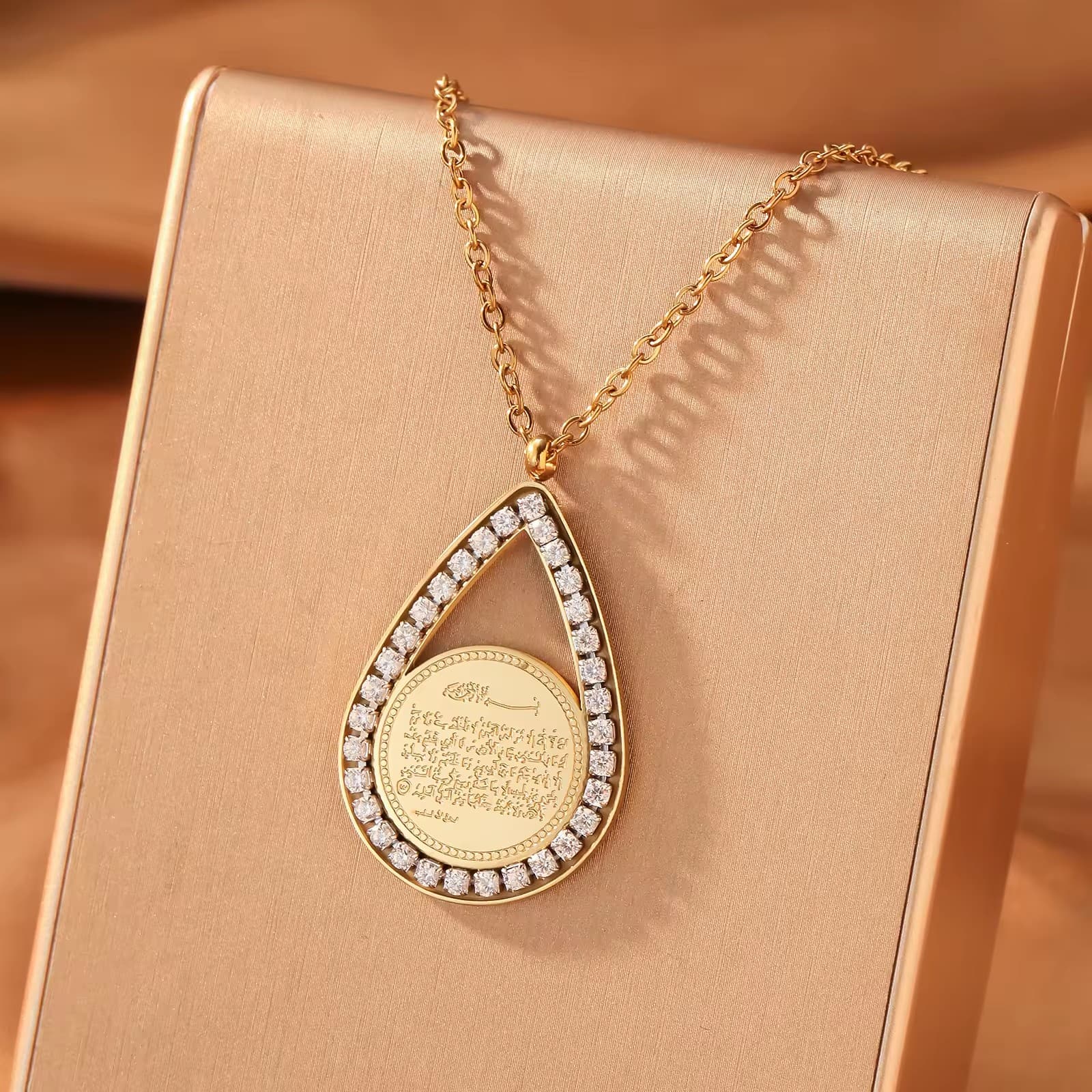 CIGAONI teardrop pendant necklace in gold finish with white mother-of-pearl center stone, front view on neutral background