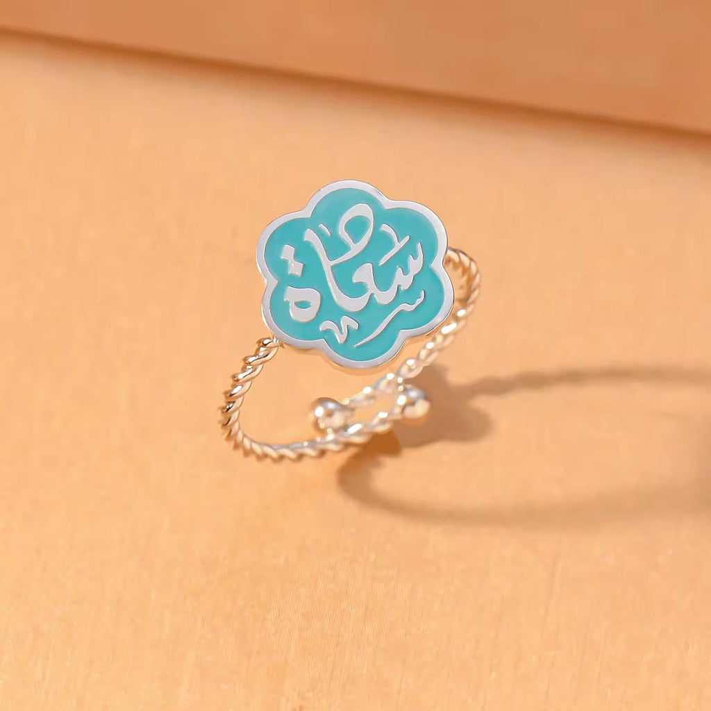 CIGAONI Bloom of Salam ruby red enamel ring in polished silver – Arabic calligraphy Salam detail visible on six-petal flower

