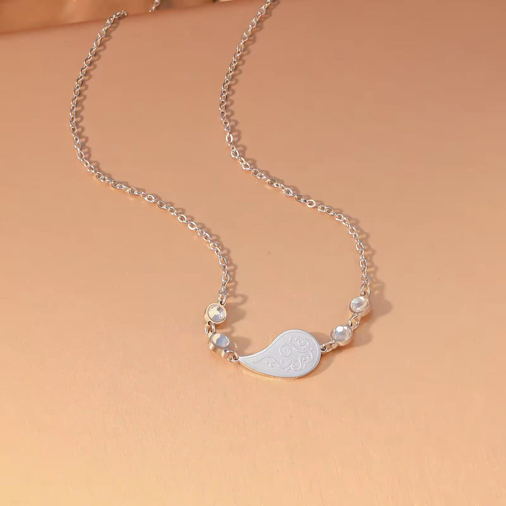 CIGAONI Dewdrop Serenity Necklace - close-up of engraved teardrop pendant with swirling filigree detail and gemstone