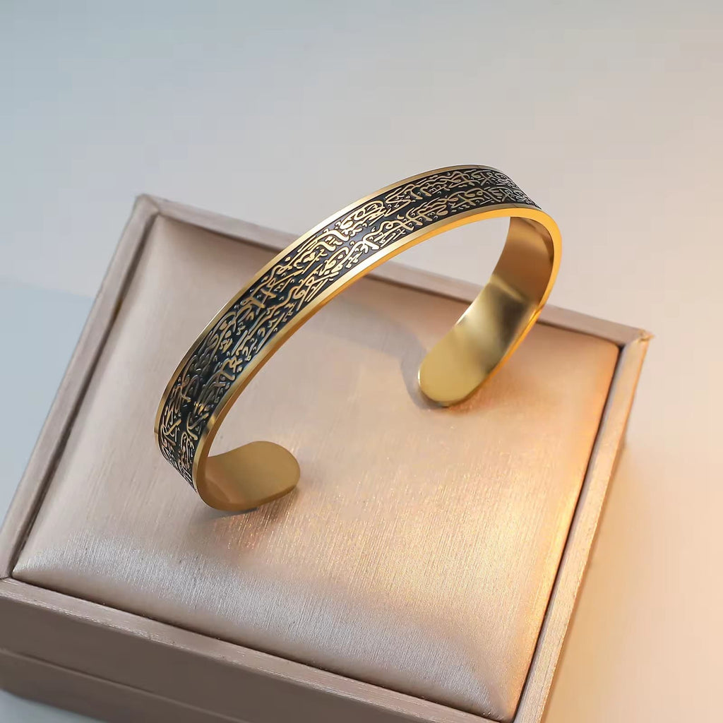 CIGAONI Sovereign Shield gold-black Ayatul Kursi open cuff bangle with dark engraved Arabic script on 18K gold frame, displayed on beige gift box