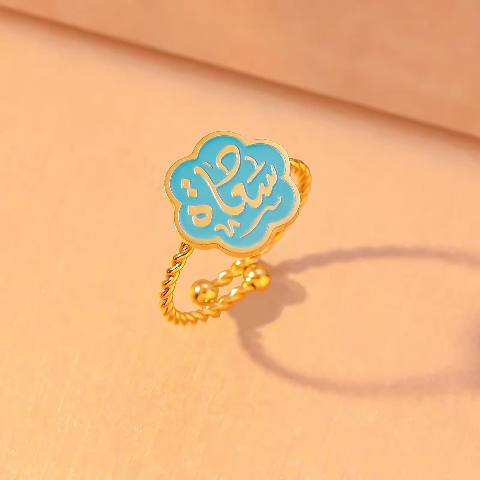 CIGAONI Bloom of Salam teal enamel ring in polished silver – Arabic calligraphy Salam detail visible on six-petal flower

