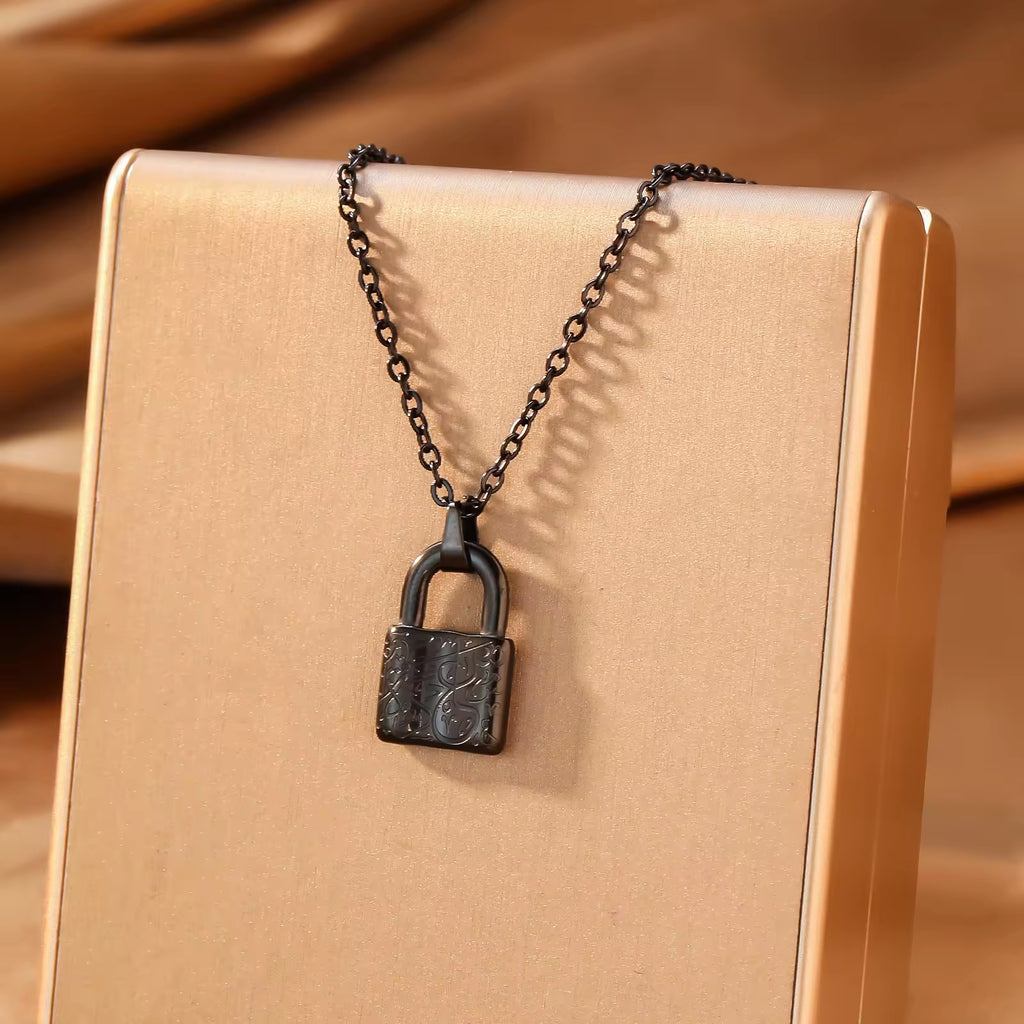 Gold lock pendant necklace on beige gift box