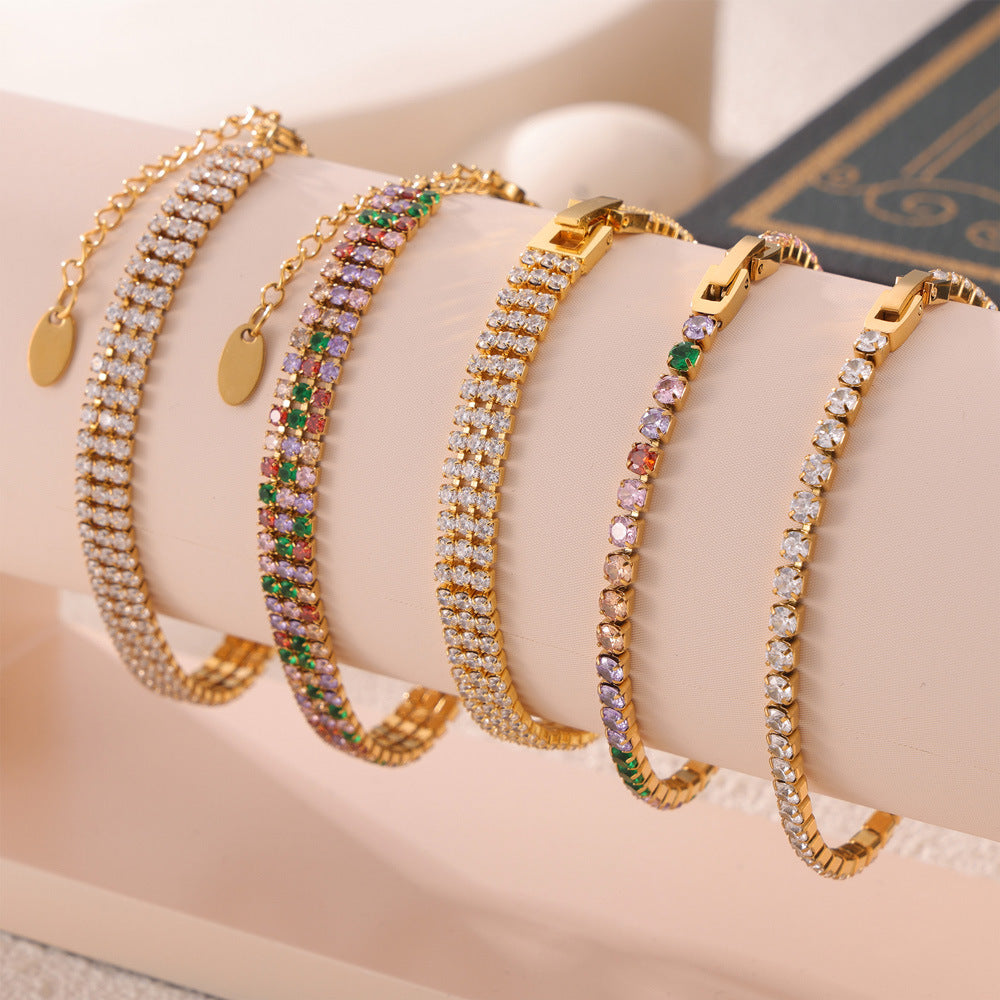 CIGAONI gold tennis bracelet set with multicolor cubic zirconia stones displayed on jewelry stand

