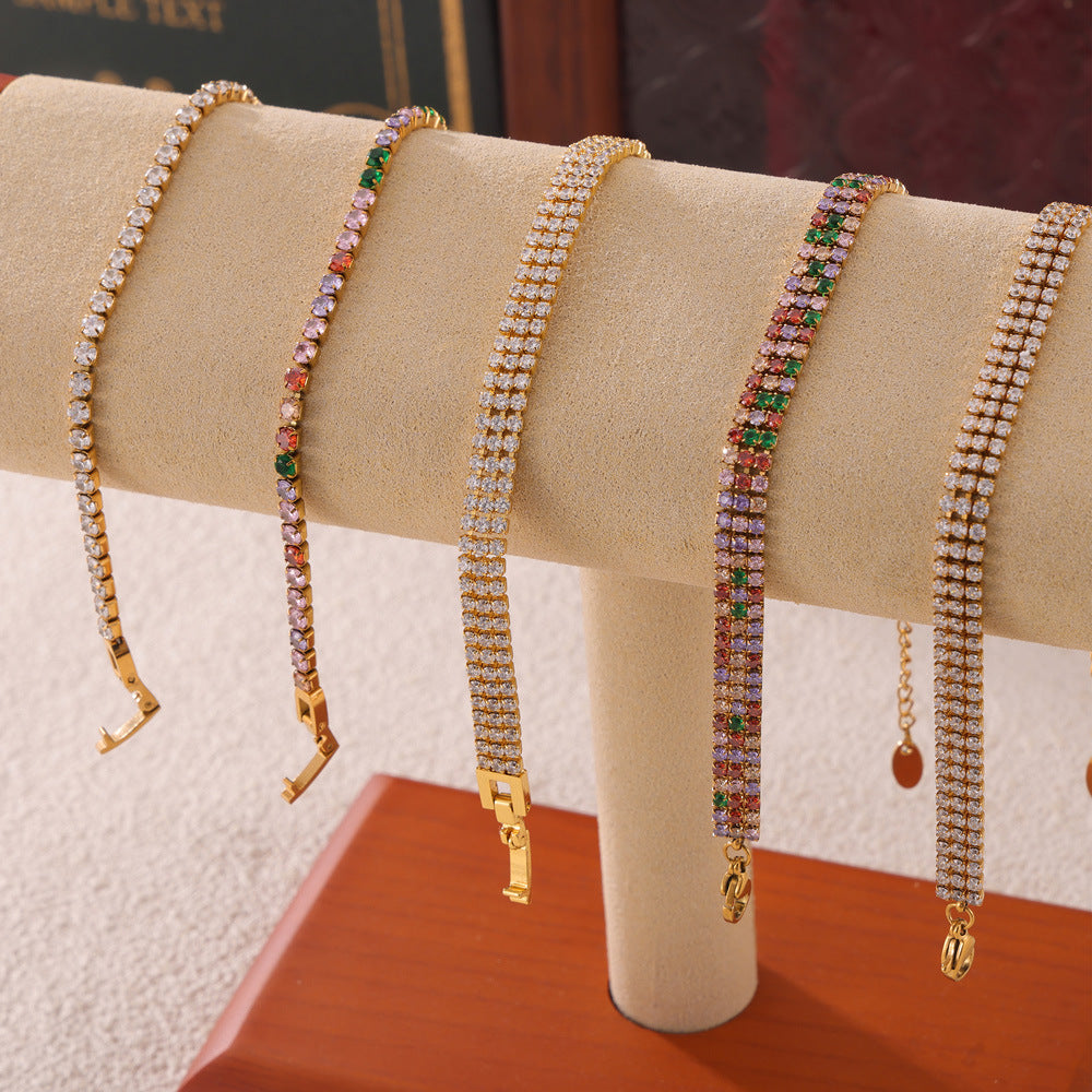 CIGAONI gold and silver tennis bracelets with multicolor zirconia held in hand, showing lobster clasp and extender chain

