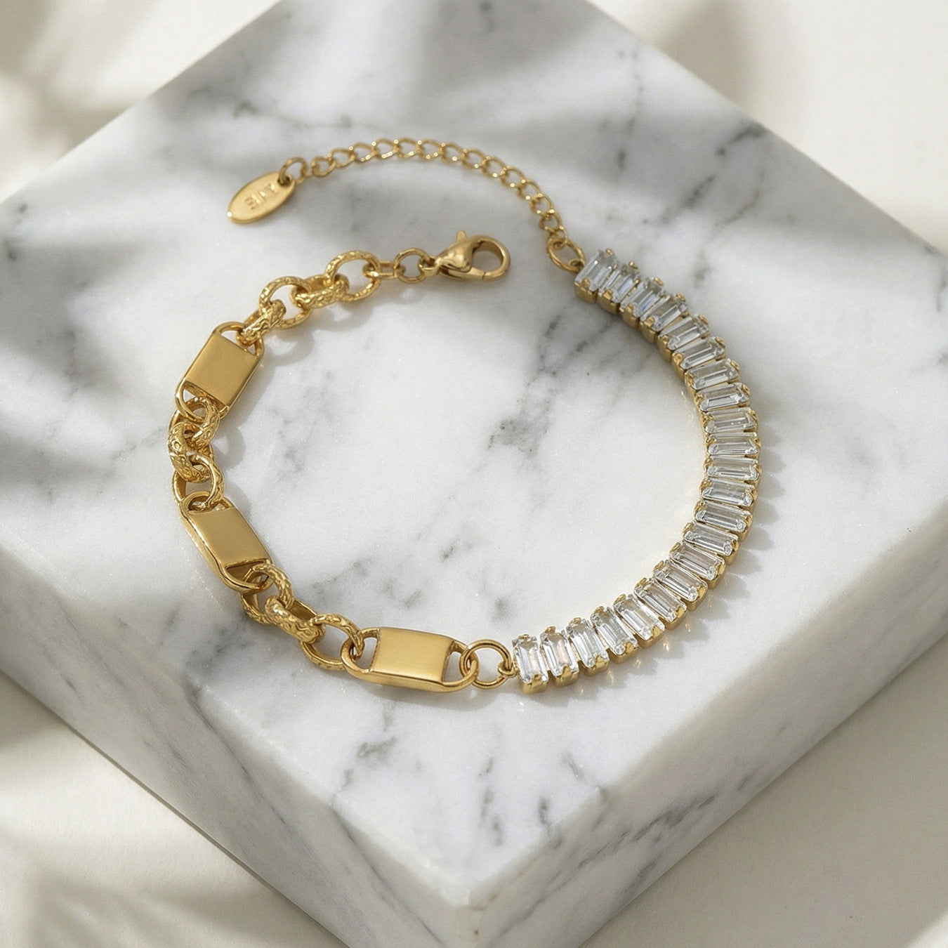 CIGAONI Pure Brilliance Gold Rectangular Tennis Bracelet – Baguette Clear Zirconia Half-Set with Gold Chain Link Half, Lobster Clasp, Flat Lay on Marble
