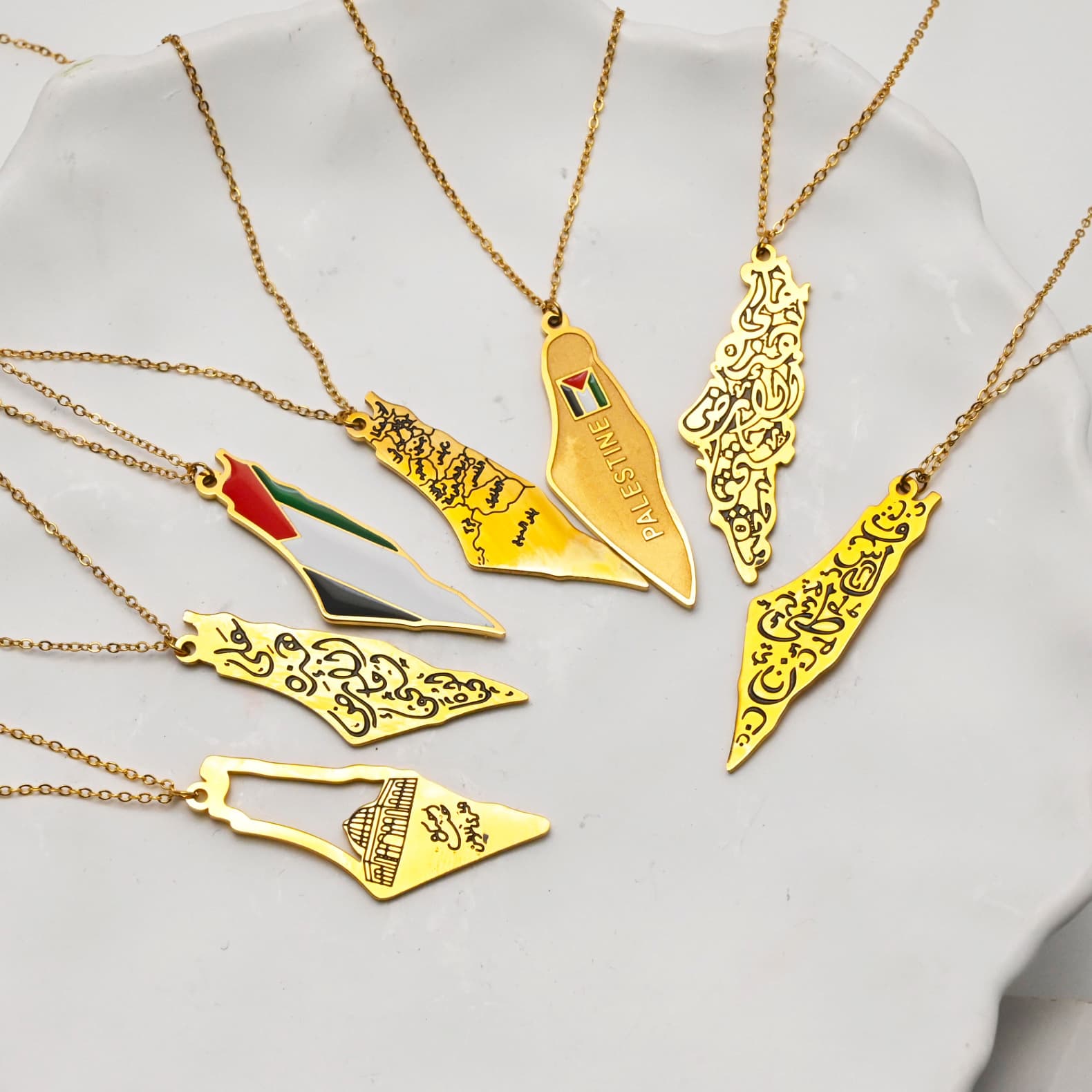 Multiple gold Palestine map necklace variants displayed in red gift box - CIGAONI