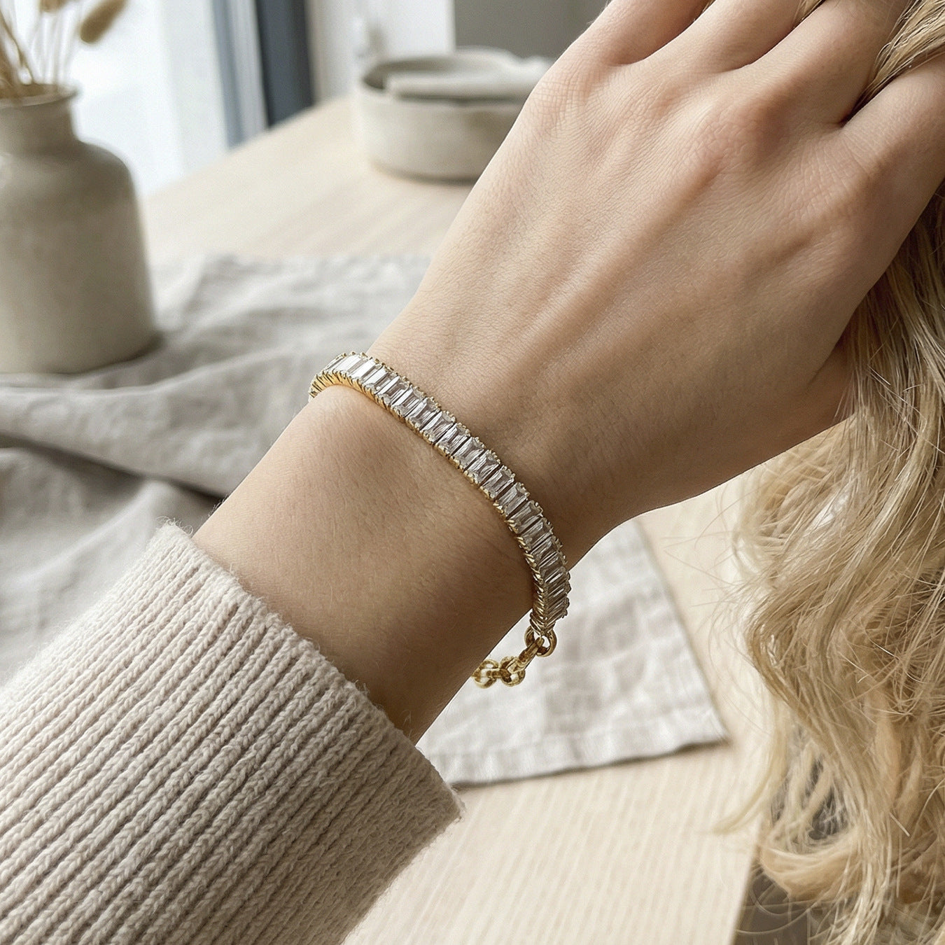 CIGAONI Pure Brilliance Gold Rectangular Tennis Bracelet – Baguette Clear Zirconia Band Worn on Wrist, Lifestyle Shot with Neutral Knit Background