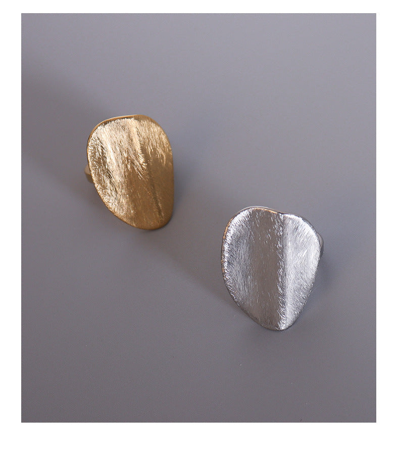 CIGAONI Quiet Muse Sculptural Ring - Gold and silver tone organic brushed sculptural rings flat lay on grey background, top view