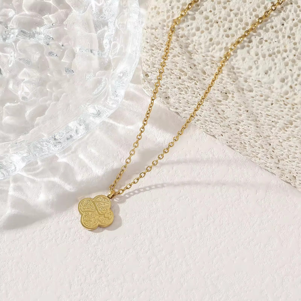 Gold four-leaf clover Shukr Arabic calligraphy pendant necklace on white background
