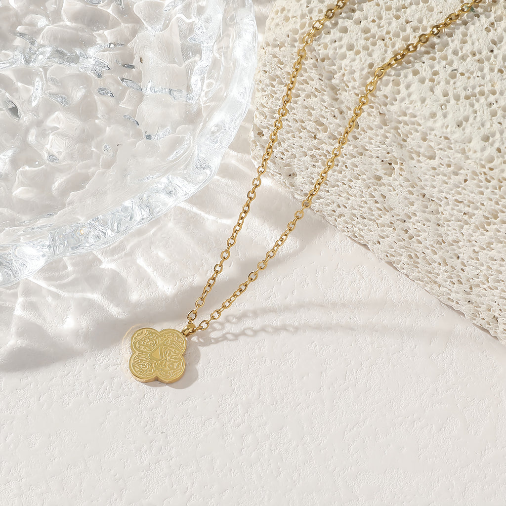 Gold four-leaf clover Tawakkul Arabic calligraphy pendant necklace on white background