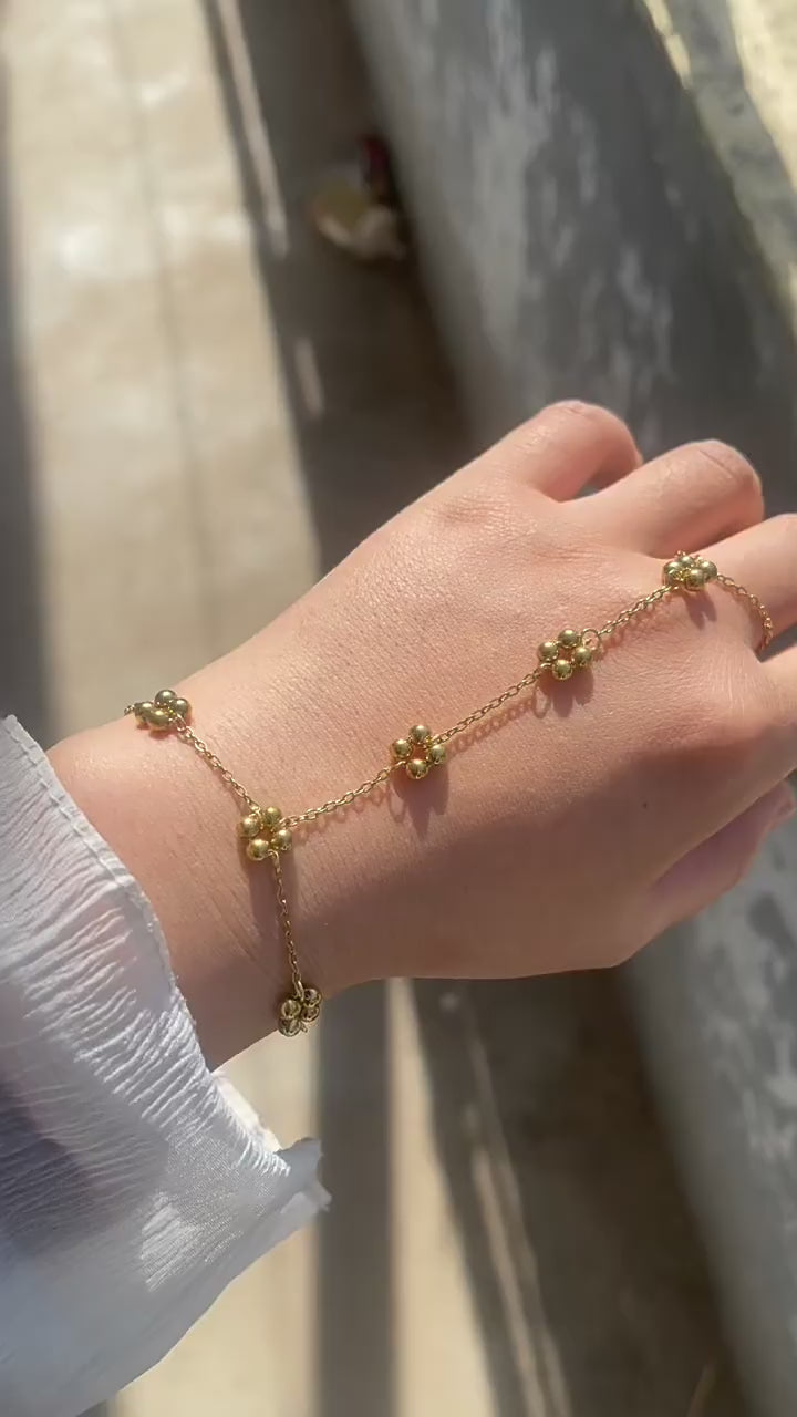 Video of model wearing CIGAONI gold flower hand chain - Elegant blossoming grace jewelry for weddings and Eid

